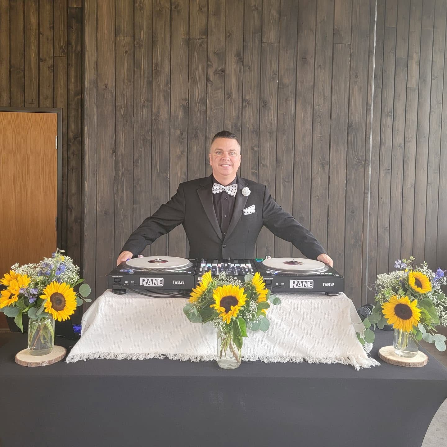 DJ Sugar's turntable setup with sunflower arrangements